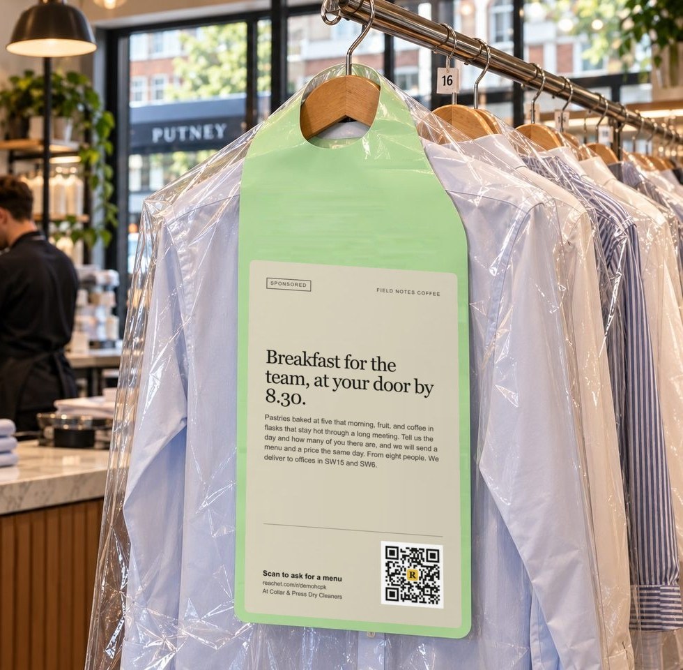A hanger tag on dry-cleaned shirts carrying a café's offer and its QR code