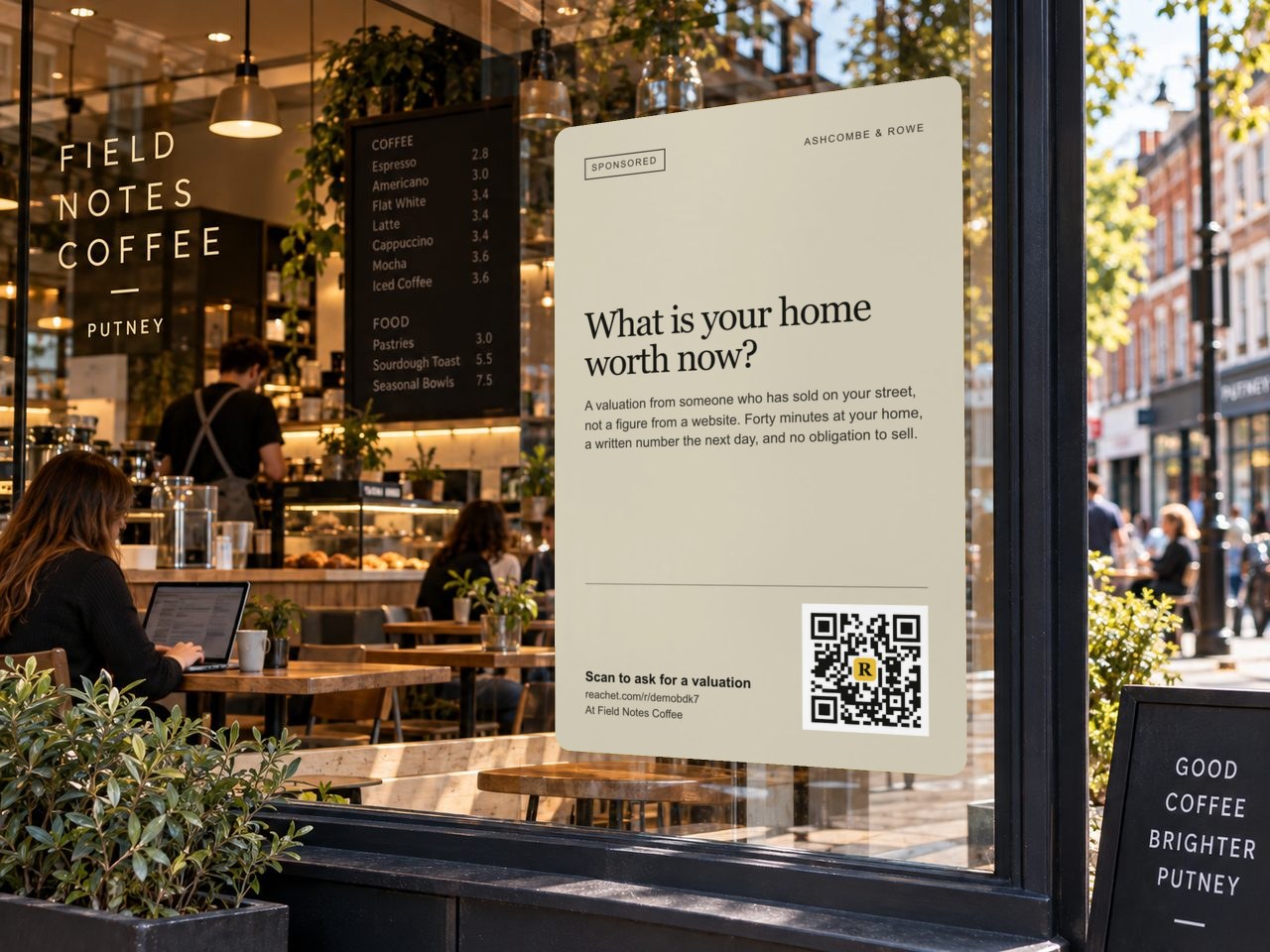A poster in a café window with an estate agent's offer and its QR code